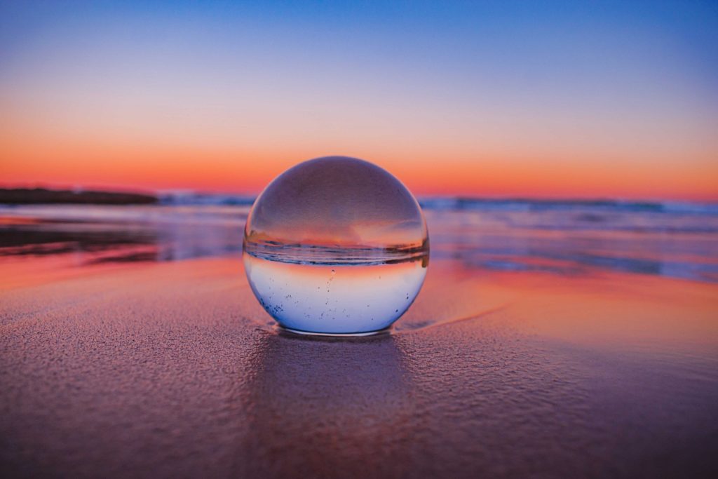 Boule de cristal posée sur une plage illustrant la difficulté de la prévision des ventes