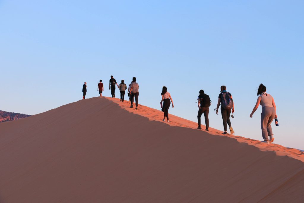 Une équipe marchant sur une dune dans le désert