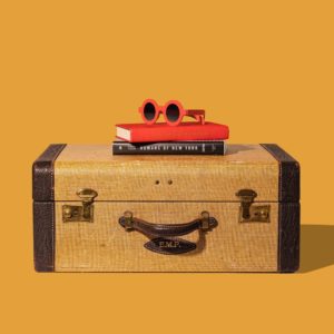 Valise de voyage ancienne avec des livres et une paire de lunettes design