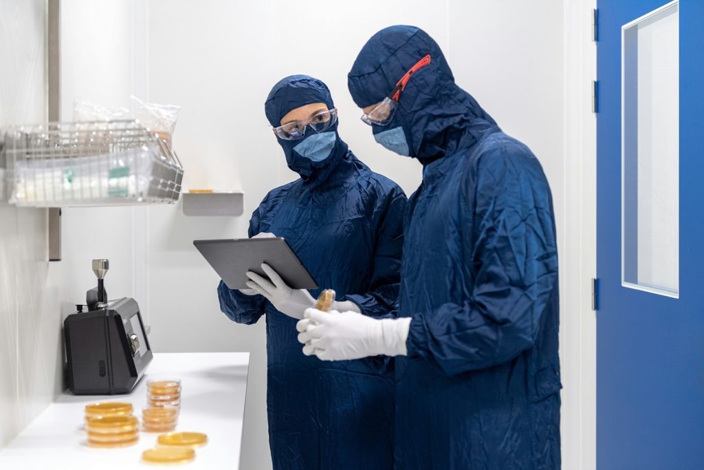 2 techniciens de laboratoire en tenue stérile qui enregistrent des données pour illustrer la défintion du DLE - dossier de lot électronique