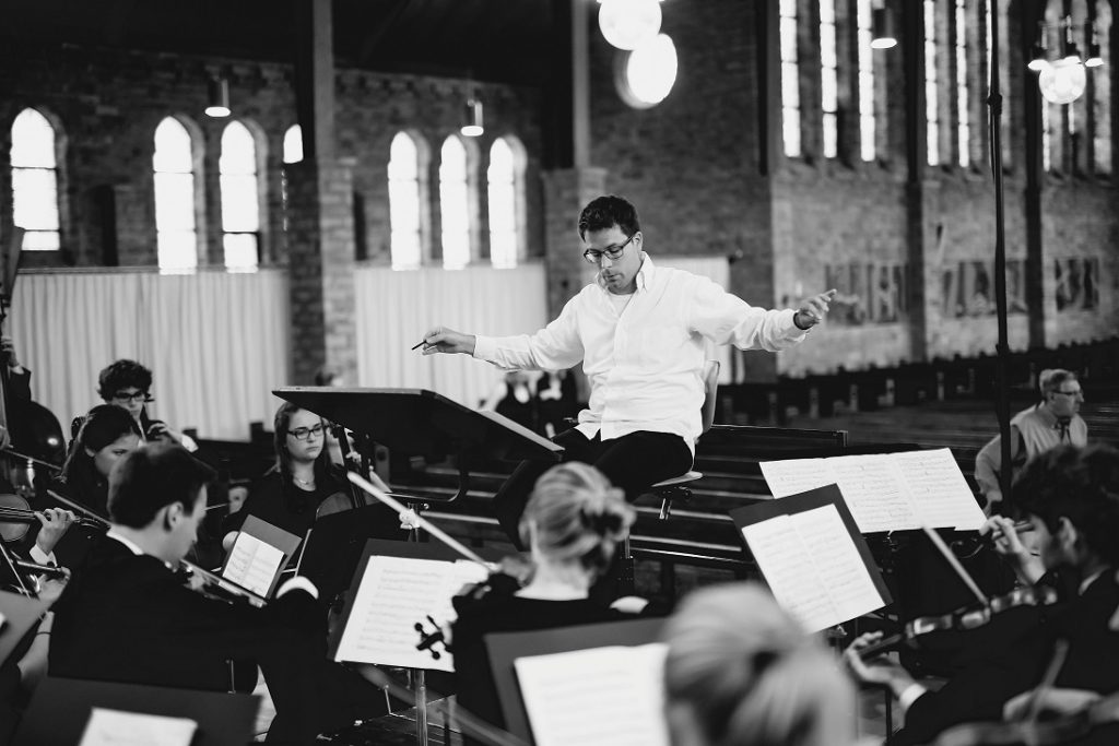Chef d'orchestre dirigeant des musiciens pour illustrer la définition du DOM-Demand-Order-Management