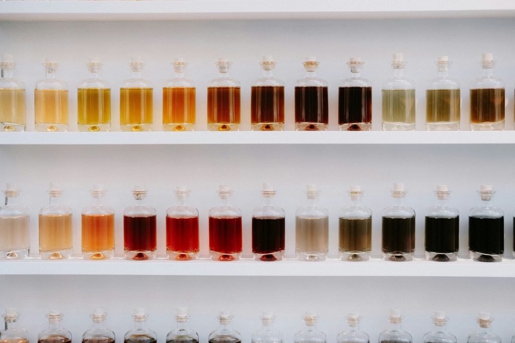bouteilles avec des contenants de couleur sur une étagère illustrant la chimie et son mode de production - batch versus continu