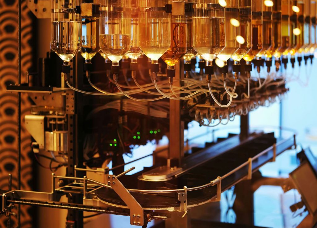 des flacons sur une chaine de fabrication de cosm&eacute;tiques pour illustrer la planification des besoins_MRP