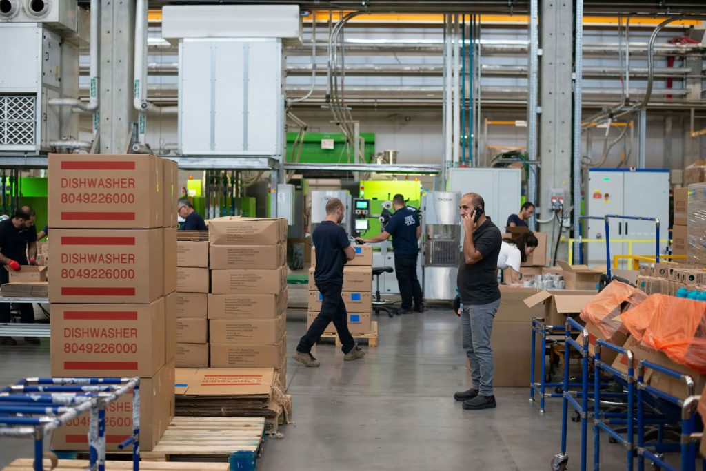 Entrep&ocirc;t 3PL avec op&eacute;rateurs et cartons en pr&eacute;paration pour illustrer l'internalisation ou l'externalisation de la logistique