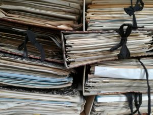 classeurs papier empilés illustrant ECM ERP Infor Blending et GED native